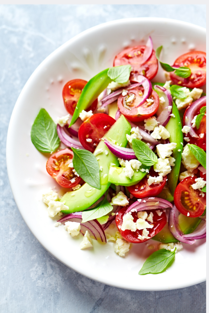 Ensalada anticáncer con tomates cherry, aguacate, cebolla morada, queso feta y albahaca fresca, apta para pacientes en quimioterapia