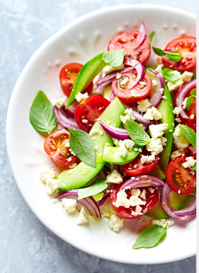 Ensalada anticáncer con tomates cherry, aguacate, cebolla morada, queso feta y albahaca fresca, apta para pacientes en quimioterapia